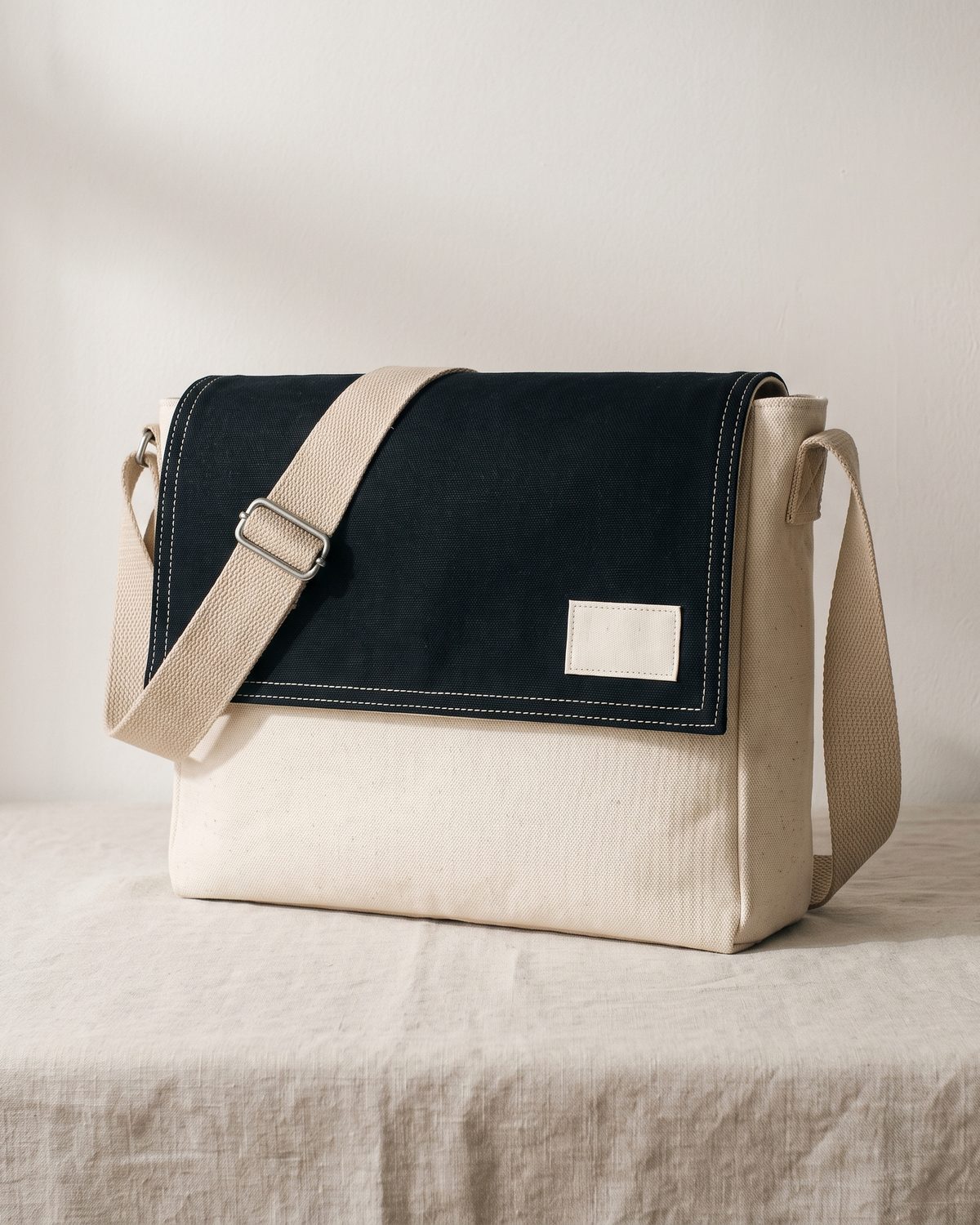 Besace Atelier en toile de coton 16 oz, rabat surpiqué et bandoulière réglable, posée debout