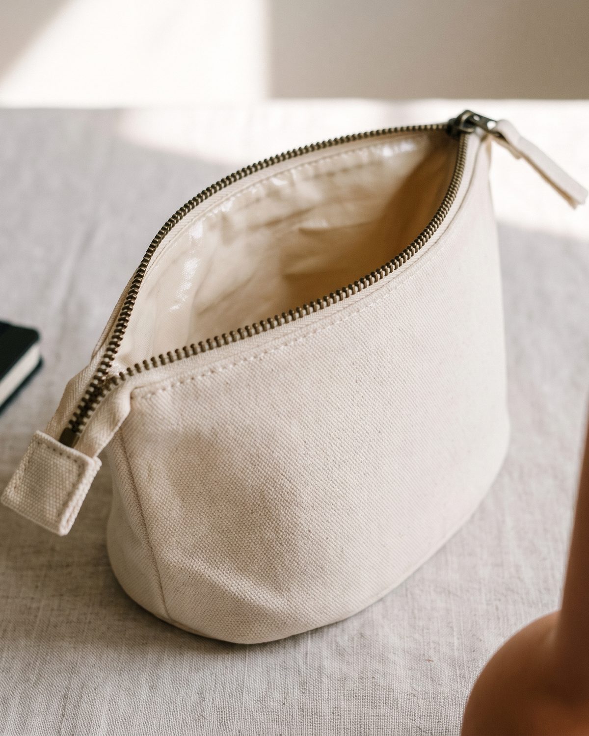 Trousse en toile de coton 12 oz, fond arrondi, ouverte sur une table